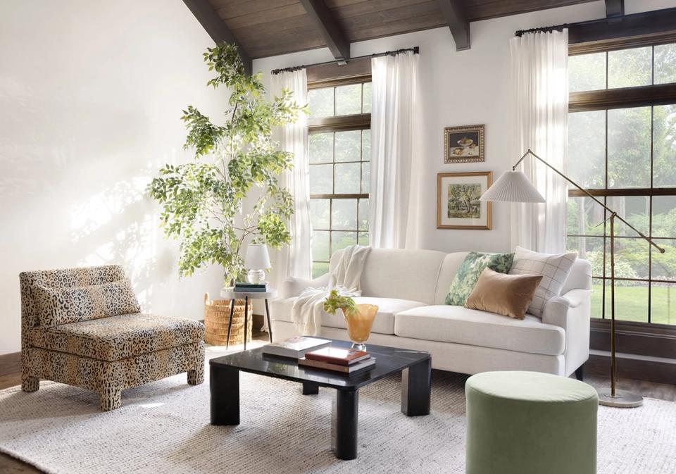 Bright, airy living room with neutral palette, natural light, woven accent chair, cream sofa, and potted greenery creating a serene, organic aesthetic