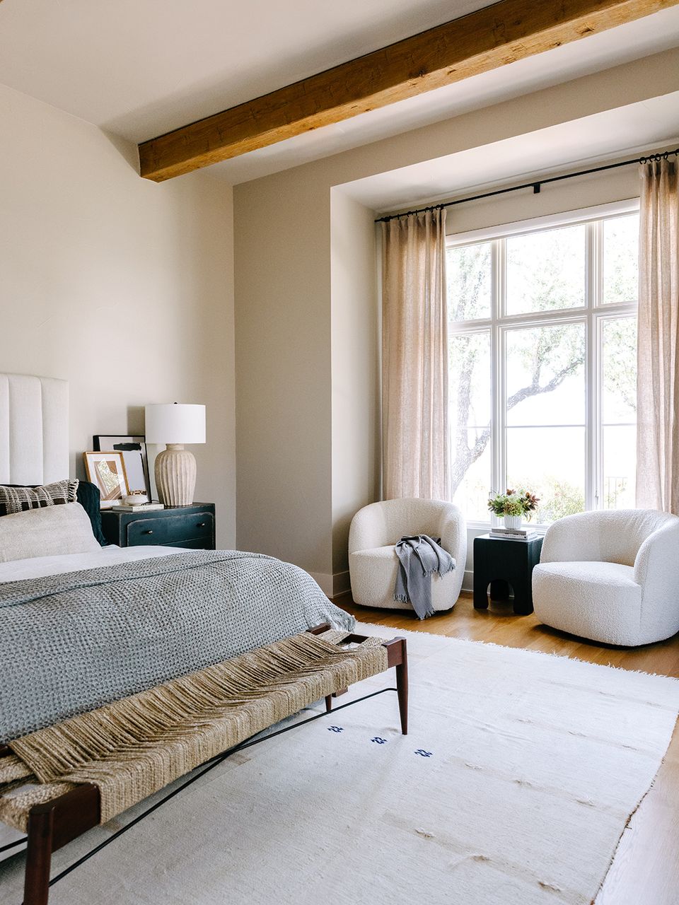 Calm LA-modern bedroom with natural wood beams, white furnishings, and soft neutral color palette