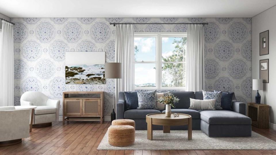 Classic New England living room with patterned wallpaper, navy sofa, and warm wood furnishings
