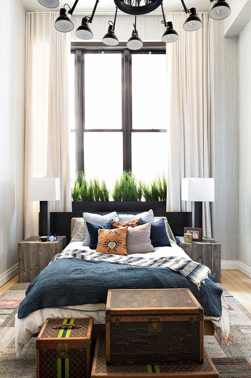 Industrial-modern bedroom blending masculine dark tones with warm textures and statement black lighting