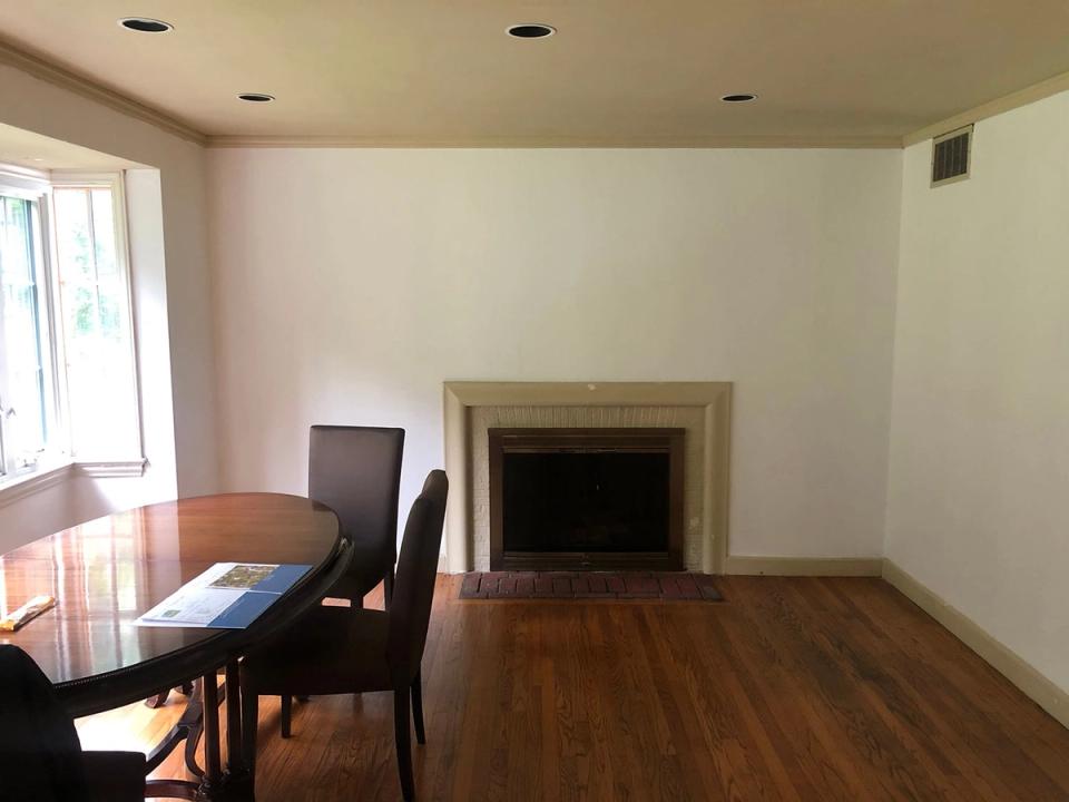 Transitional dining room with dark wood floor, fireplace, and minimalist furnishings