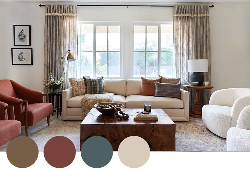 Contemporary living room mixing terracotta, sage green, and cream with layered textures, burgundy accent chair, and natural linen curtains.