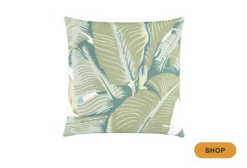 Tropical-inspired pillow with layered green and blue palm leaf motif