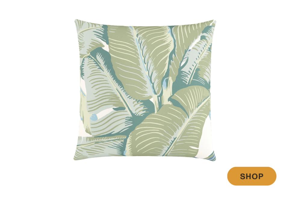 Tropical-inspired pillow with layered green and blue palm leaf motif