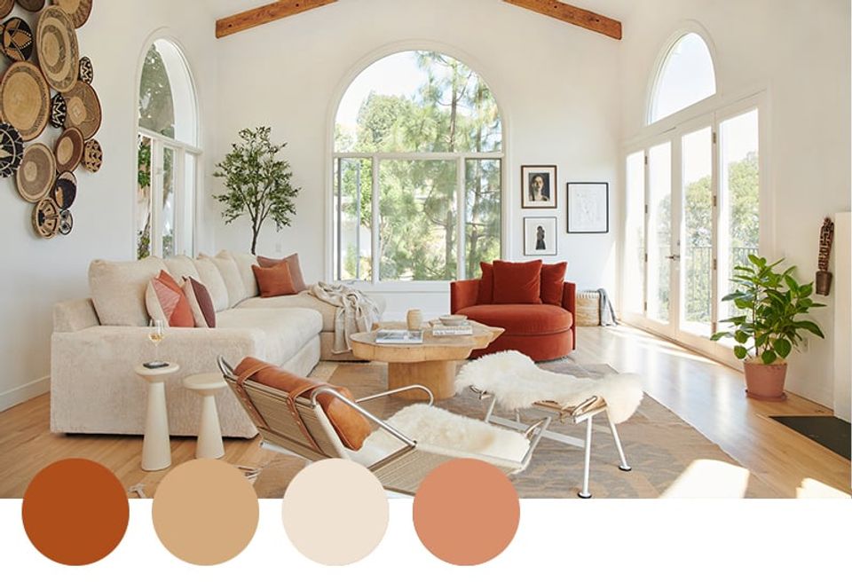 Warm, earthy living room with rust and terracotta tones, natural wood beams, and abundant natural light for a welcoming, organic feel