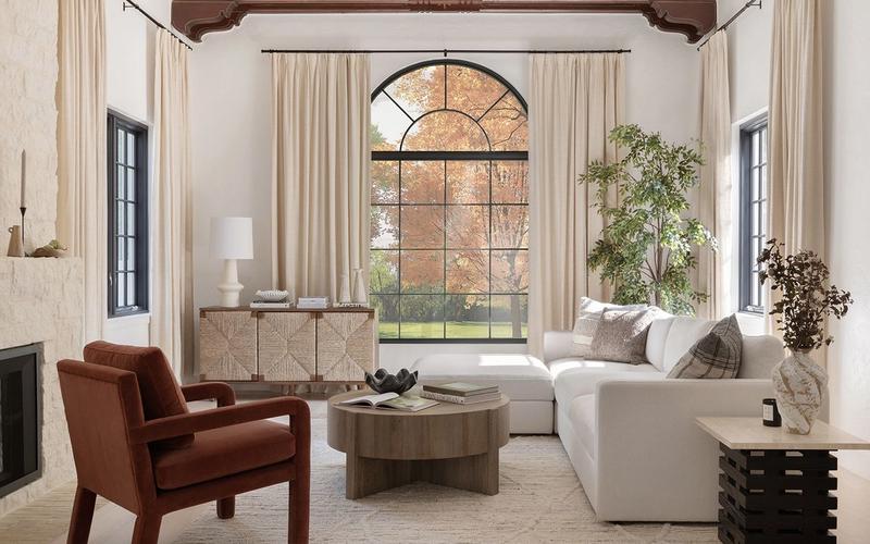 Sophisticated living room with warm wood beams, cream drapery, burgundy leather chair, and modern furnishings creating elevated, timeless elegance.