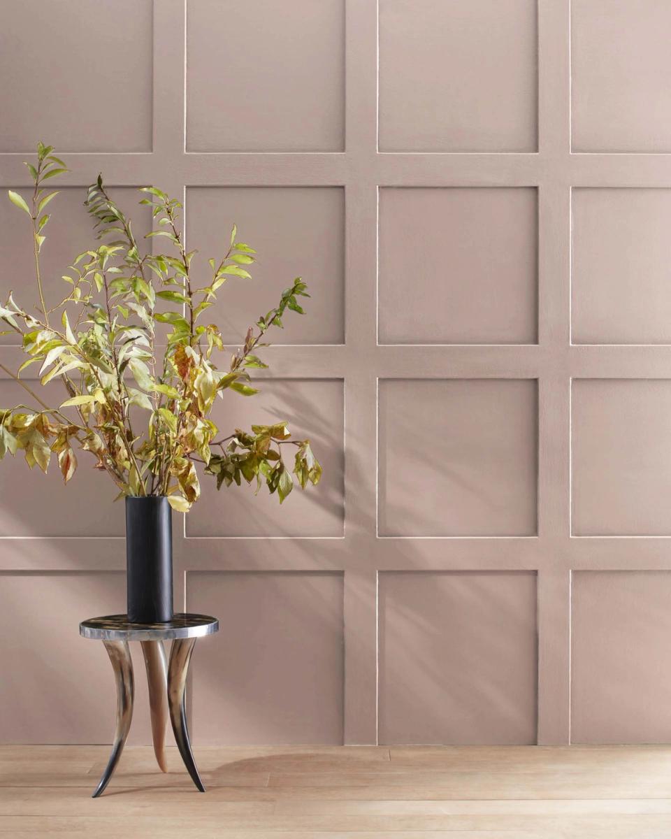 Soft taupe paneled wall with transitional design featuring woven black vase and delicate yellow branches