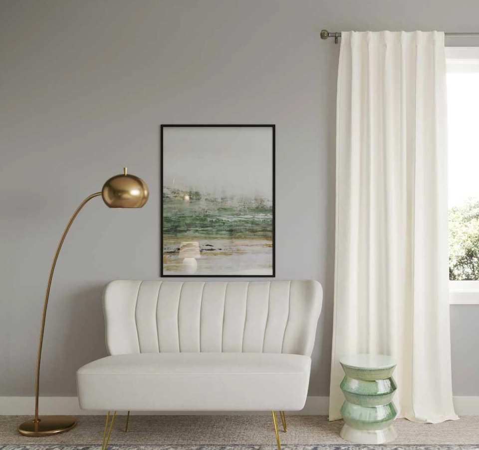 Minimalist modern interior with cream curved sofa, brass lamp, and sage accessories