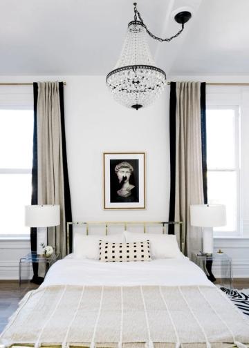 Elegant black and white canopy bedroom with crystal chandelier, striped curtains, and minimalist monochromatic aesthetic