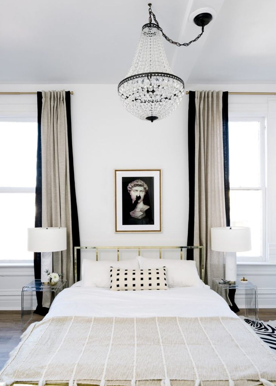 Elegant black and white canopy bedroom with crystal chandelier, striped curtains, and minimalist monochromatic aesthetic