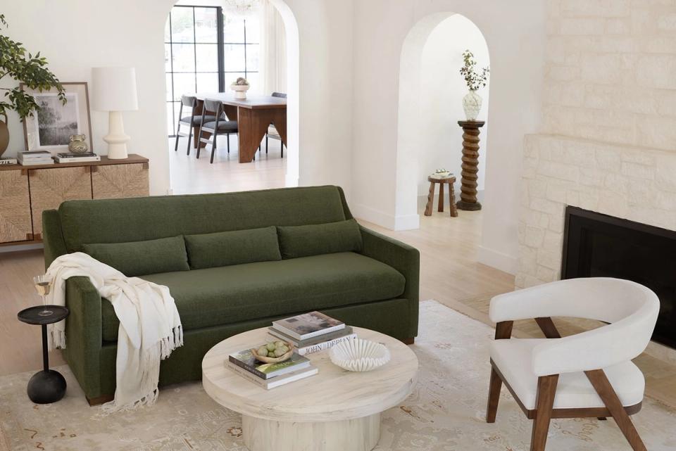 Scandinavian living room with forest green sofa, light wood furniture, and cream accents creating warm, cohesive mixed-wood aesthetic