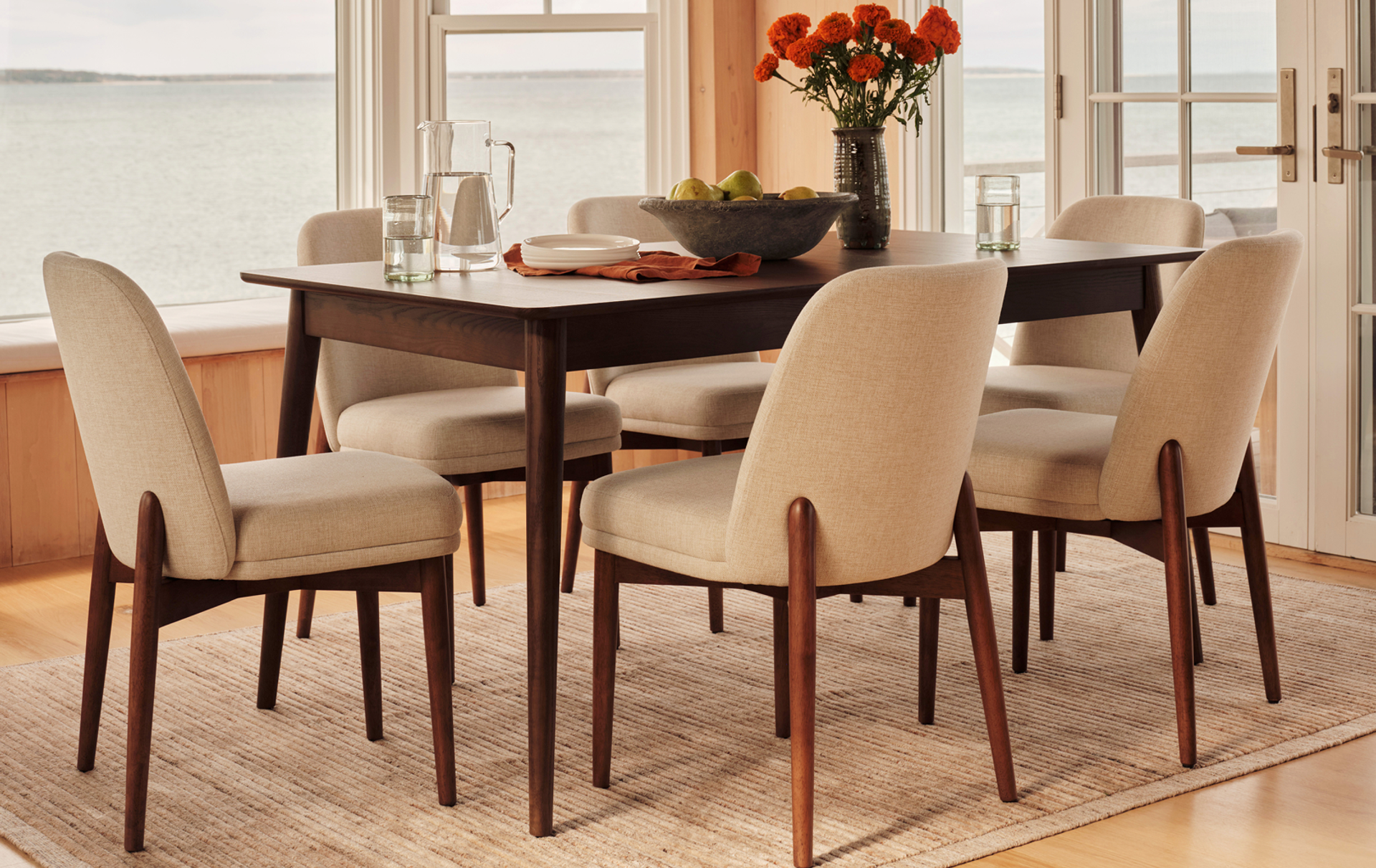 A mid-century modern dining room overlooking the water