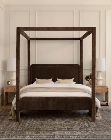 Transitional bedroom with dark wood canopy bed, cream walls, paneling, and neutral bedding creating elegant, serene atmosphere.