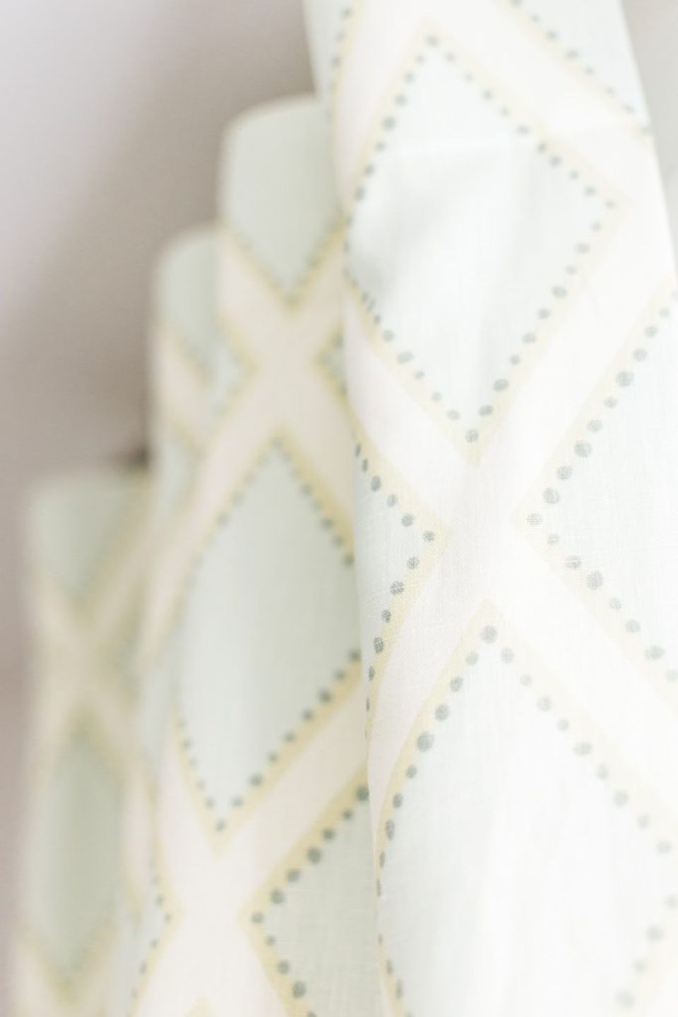 Close-up of cream linen curtain panel with subtle beaded diamond quilting detail