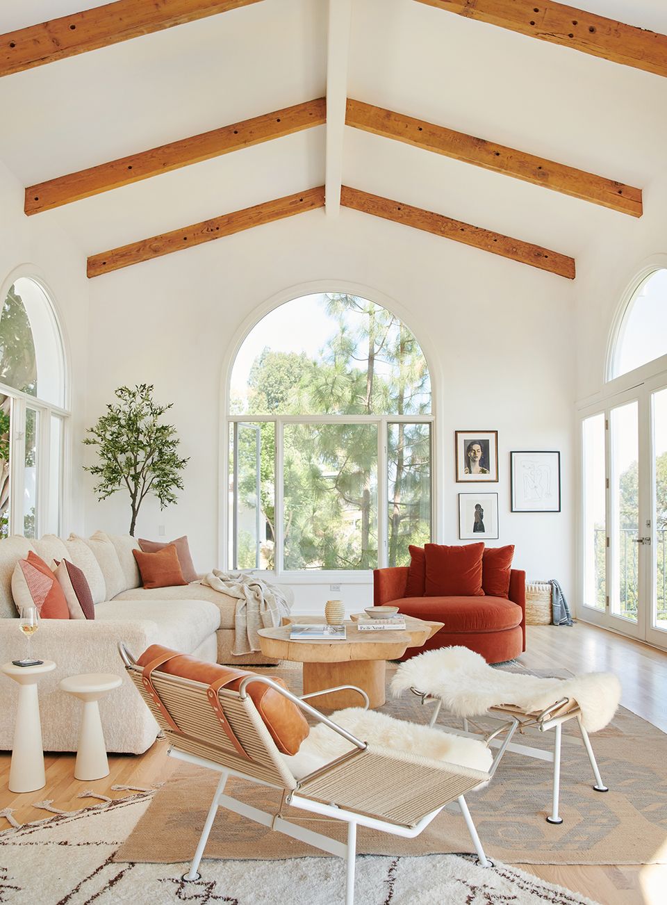Contemporary farmhouse with exposed beams, rust and cream tones, mid-century seating