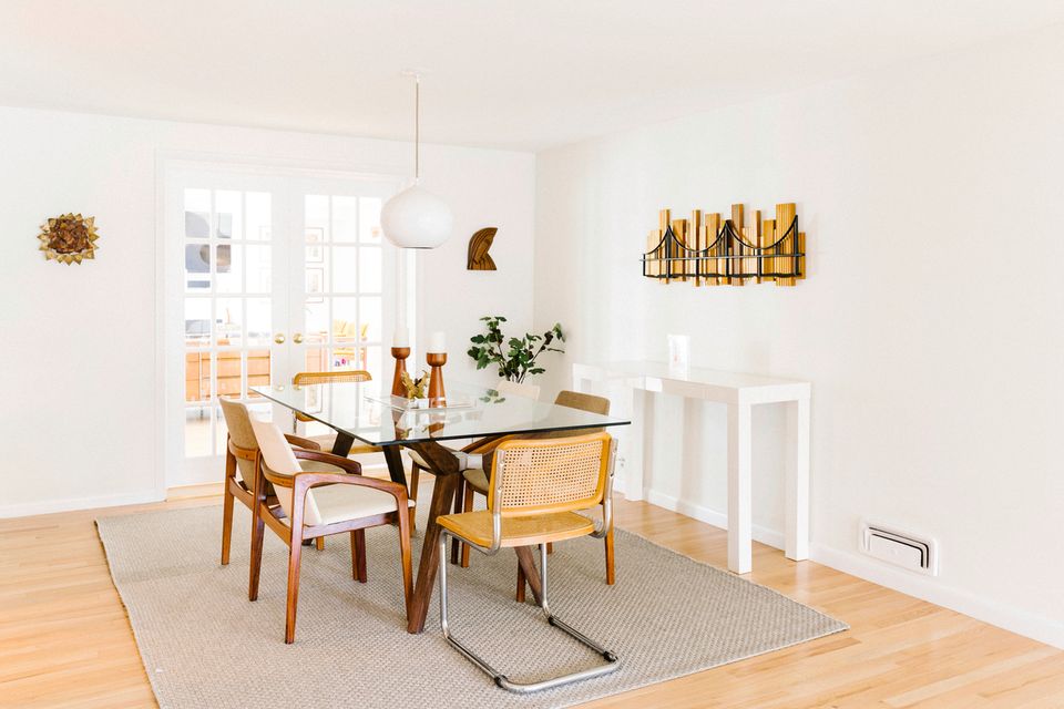 Serene mid-century dining area with warm wood tones, minimal décor, and bright natural light