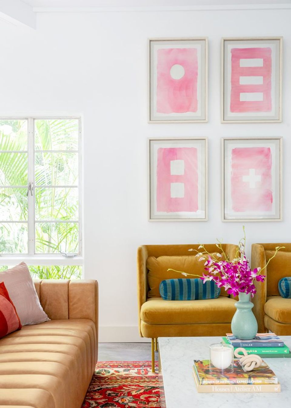 Maximalist living room with pink abstract art grid and golden velvet mid-century sofa