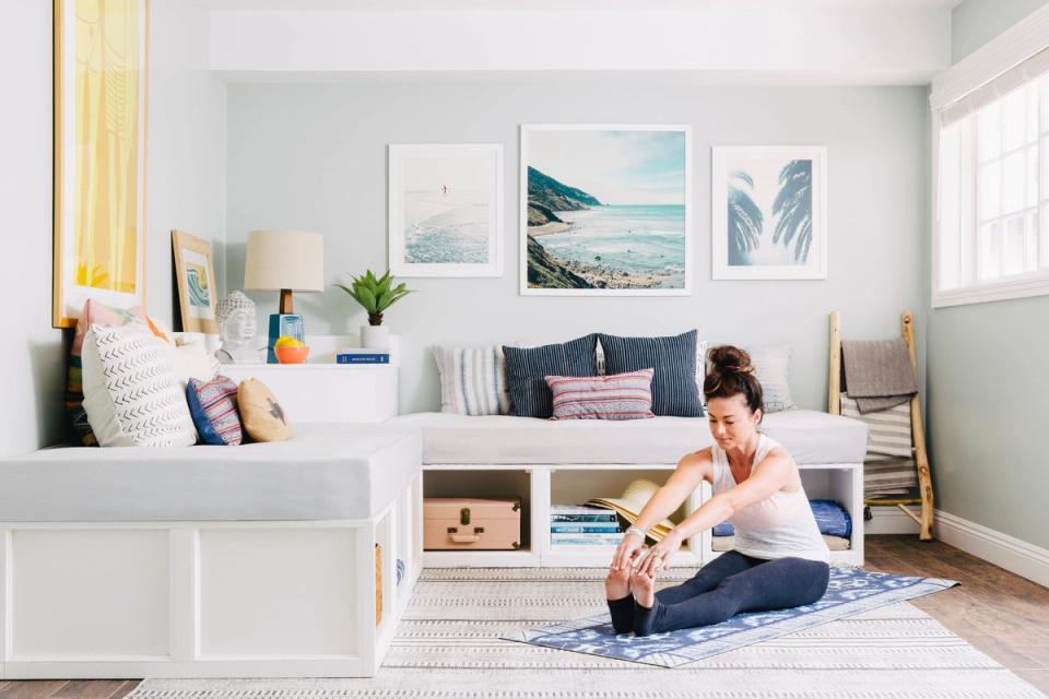 Serene coastal-inspired bedroom with soft neutrals, blue accents, and gallery wall art creating a calm, light-filled sanctuary