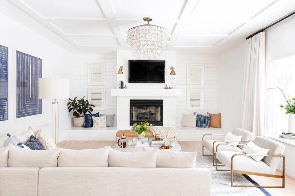 Bright transitional living room with cream sectional, fireplace mantel, and modern pendant lighting