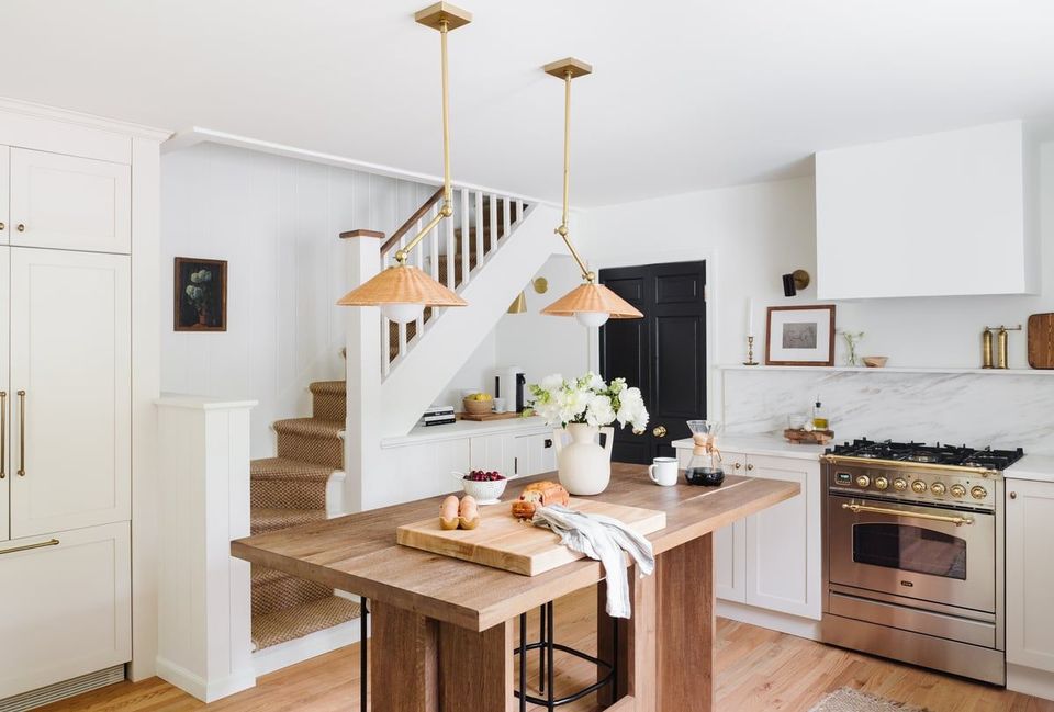 Bright, modern farmhouse kitchen with wood island, brass pendant lights, and clean white cabinetry
