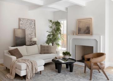 Scandinavian-inspired lounge with cream sofa, mid-century wooden chair, and minimalist aesthetic