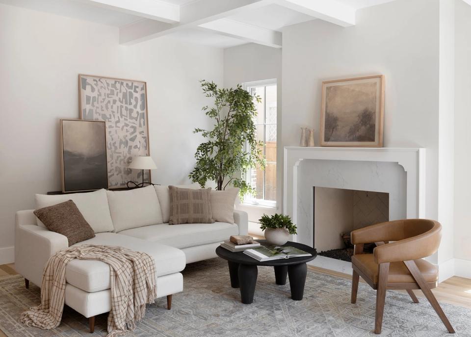 Scandinavian-inspired lounge with cream sofa, mid-century wooden chair, and minimalist aesthetic