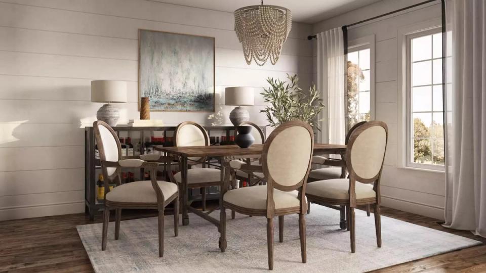 Elegant transitional dining room with warm wood table, neutral upholstered chairs, and natural light from glass doors