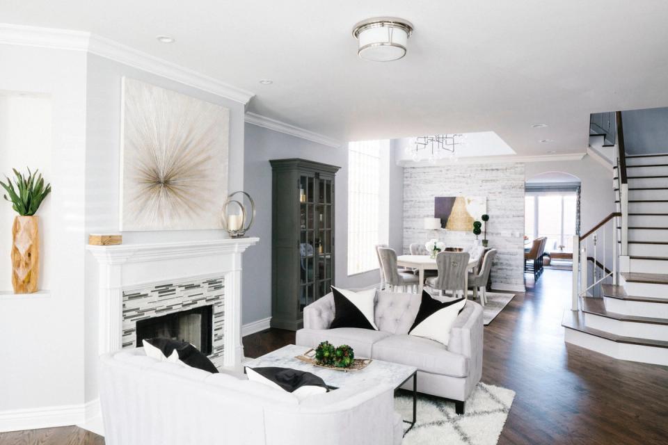 Bright, modern living room with crisp white walls, dark green accent wall, and warm wood floors creating sophisticated contrast