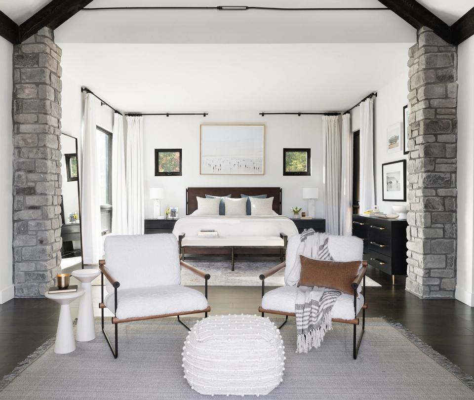 Contemporary primary bedroom with exposed brick archway, neutral tones, and balanced symmetrical layout
