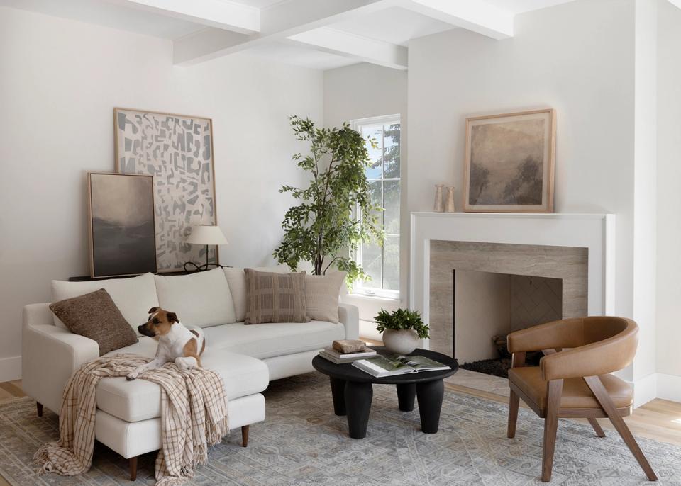 Contemporary living room with white fireplace, cream sectional, and natural wood furniture in serene, organic aesthetic.