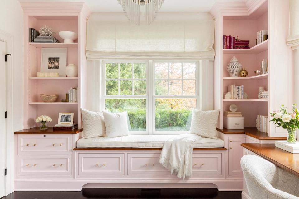 Soft pink and white classic window seat with decorative picture moulding, creating a tranquil, feminine cottage-inspired retreat