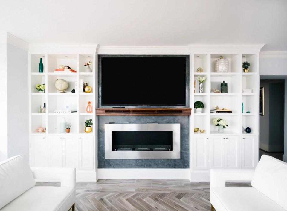 Modern minimalist living room with white built-in shelving, fireplace, and sleek entertainment center