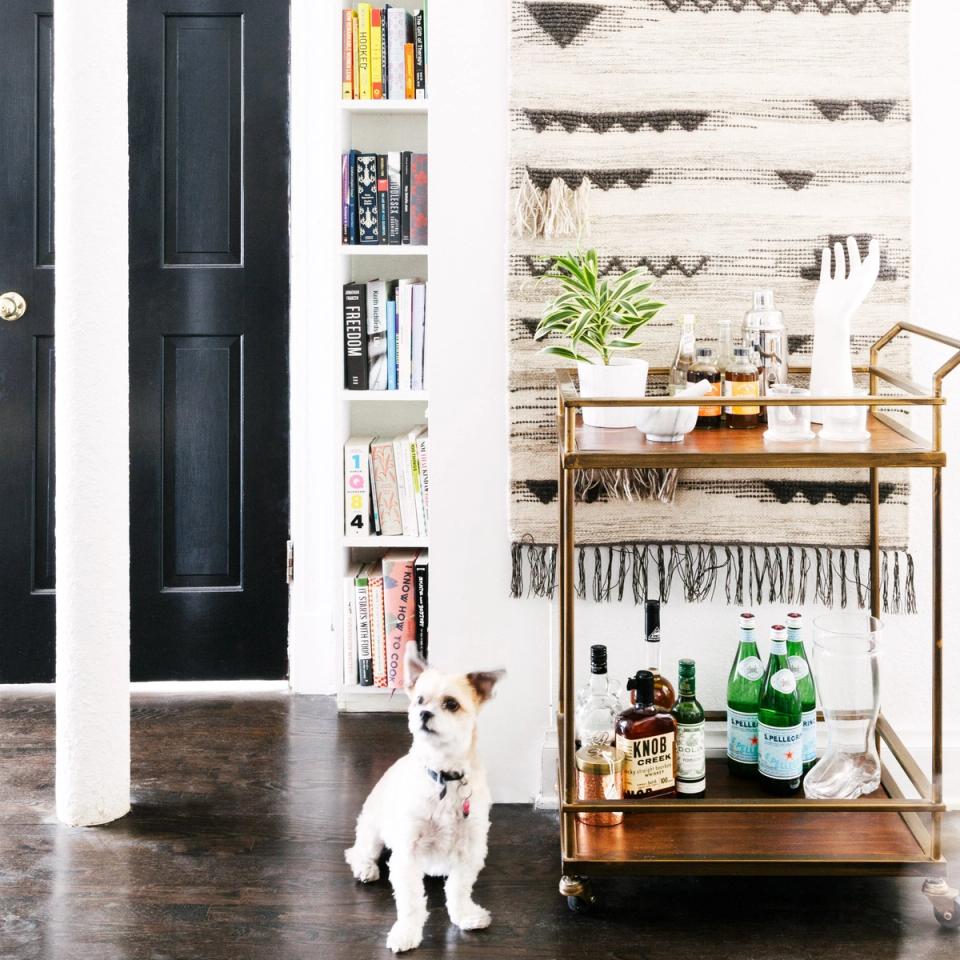 Scandinavian workspace with natural wood shelving, woven wall tapestry, and minimalist storage against shiplap backdrop.