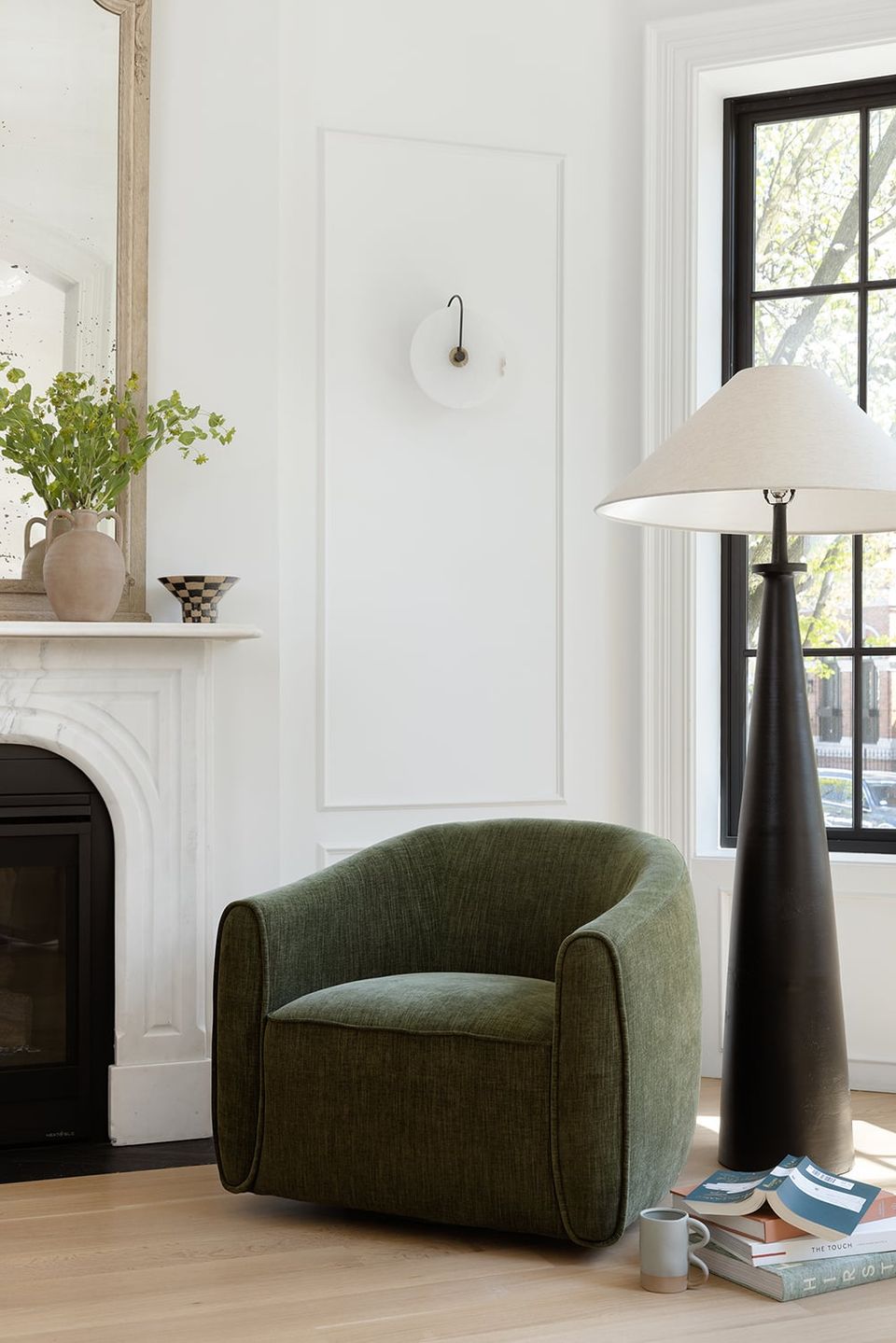 Scandinavian interior with olive green curved swivel chair and minimalist décor