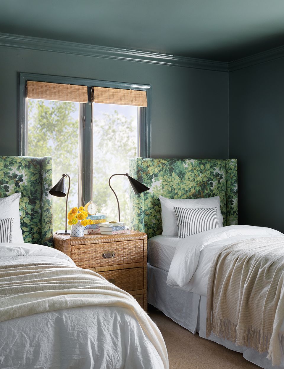Tranquil guest bedroom with deep teal walls, botanical green headboards, and natural wood accents