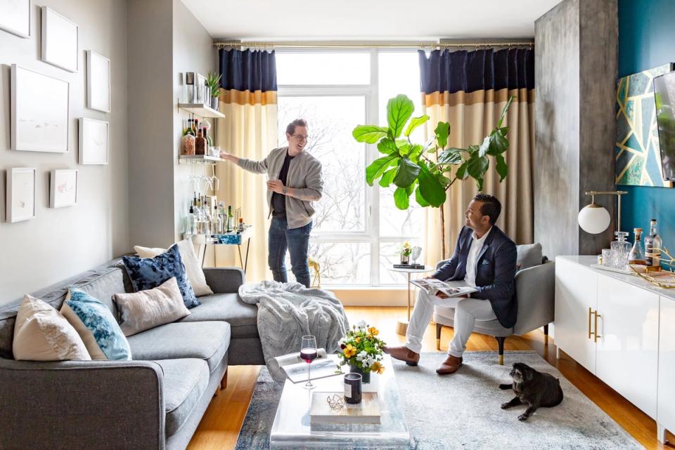 Eclectic modern living room blending warm neutrals with teal accents, layered textures, abundant plants, and natural light