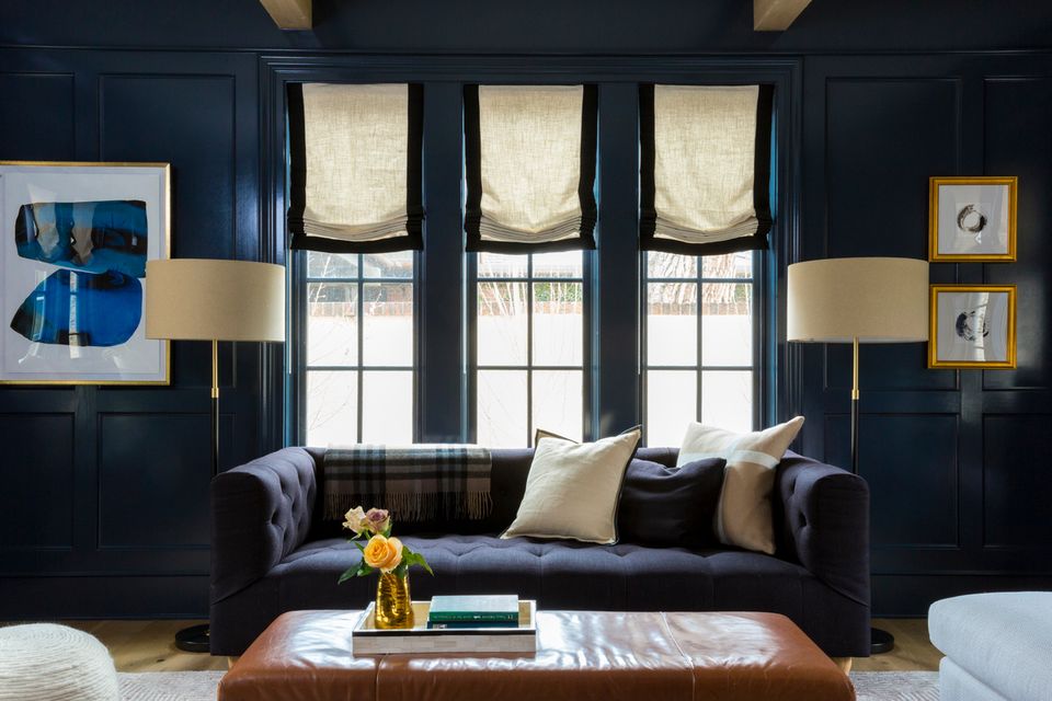 Sophisticated navy living room with brass table lamps flanking arched windows
