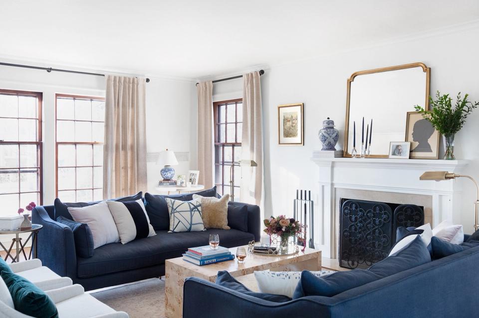 Modern living room with navy sofa, brass fixtures, and refined neutral palette
