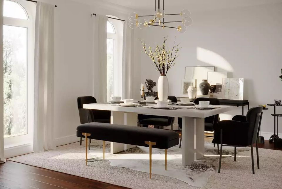 Modern minimalist dining room with warm white walls, black dining set, and warm brass lighting in an elegant monochromatic scheme.