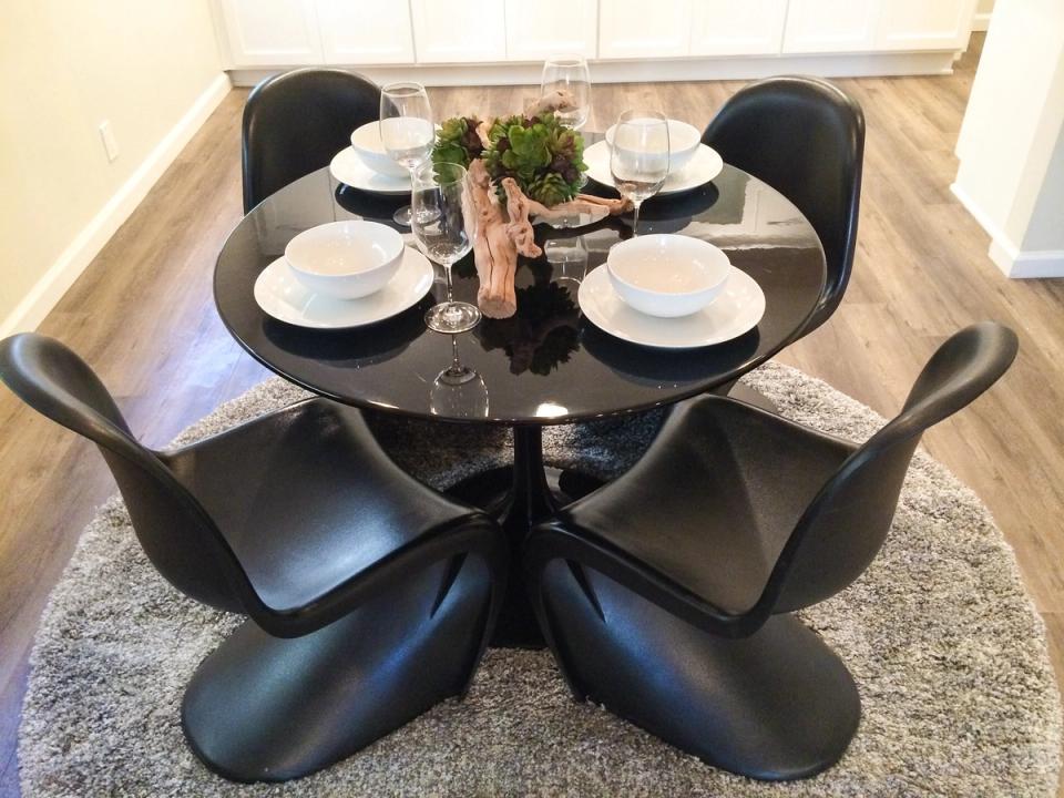 Sleek black round dining table with sculptural chairs and minimalist monochrome aesthetic