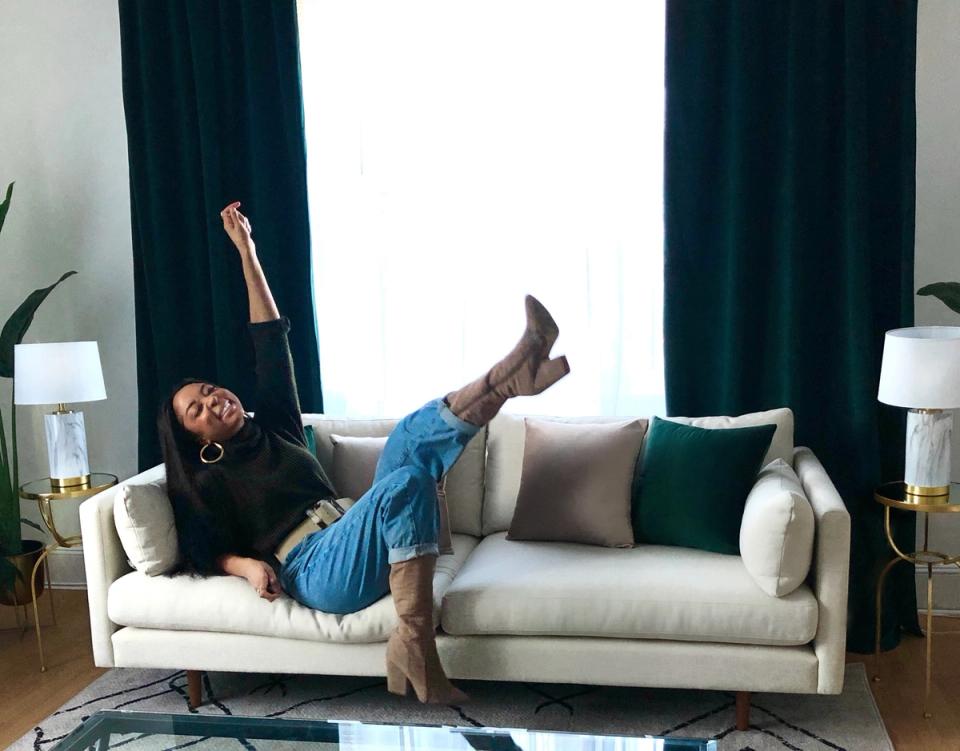 Tropical modern living room with cream sofa, teal curtains, and lush greenery creating a relaxed coastal vibe