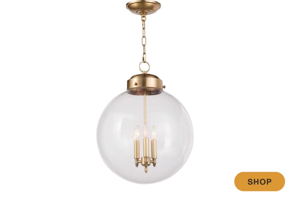 Transitional clear glass globe pendant with brass hardware and clean, timeless elegance