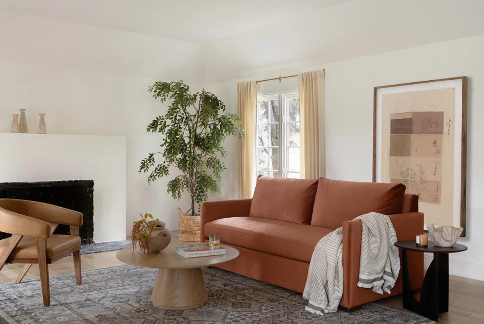 Warm, earthy living room with terracotta sofa, natural wood accents, and soft neutral palette