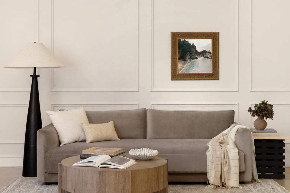 Contemporary living room featuring gray sofa, warm wood coffee table, and neutral palette with gold accents