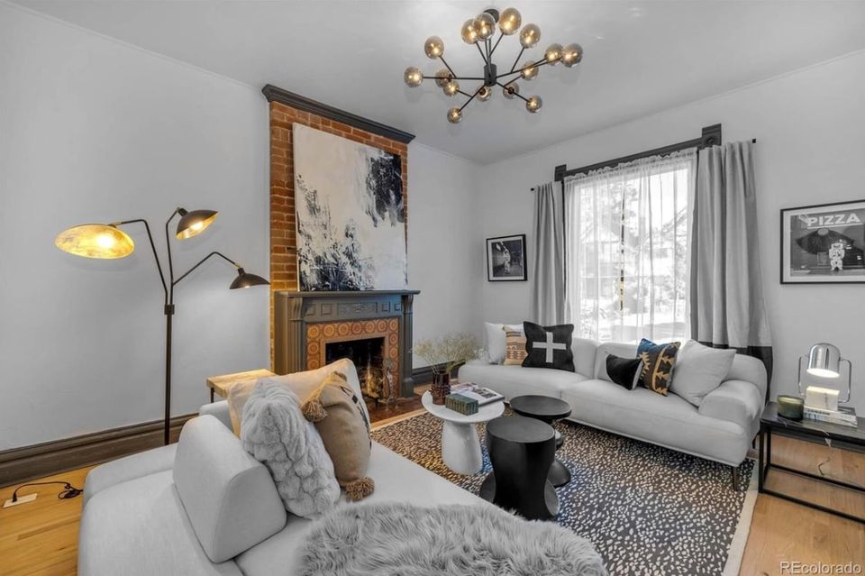 Scandinavian living room with warm wood accents, soft gray upholstery, and brass lighting creating a bright, airy minimalist aesthetic