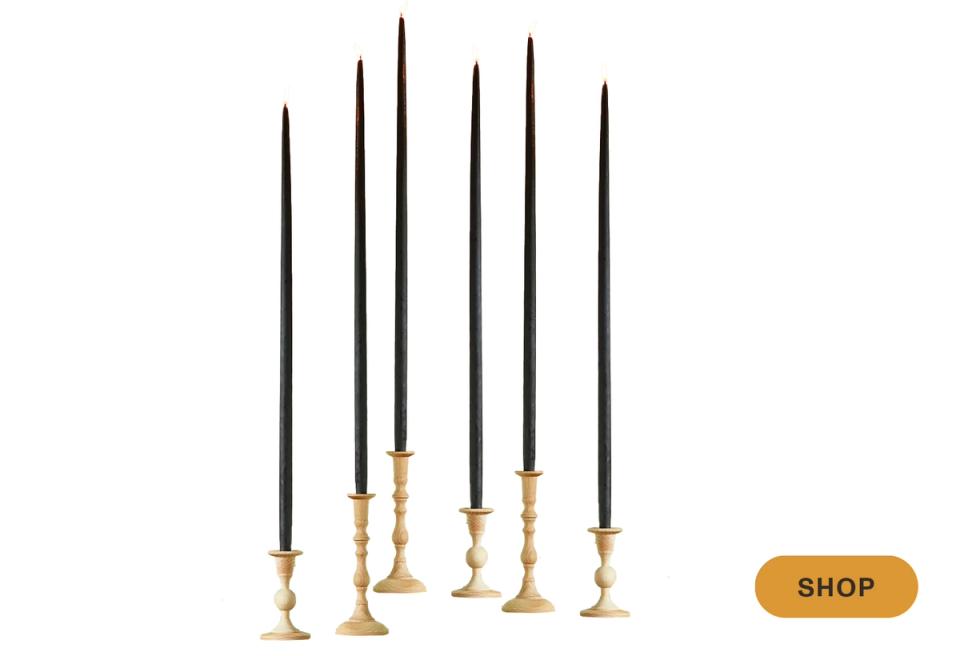 Modern black taper candles with brass holders in mixed heights for minimalist elegance