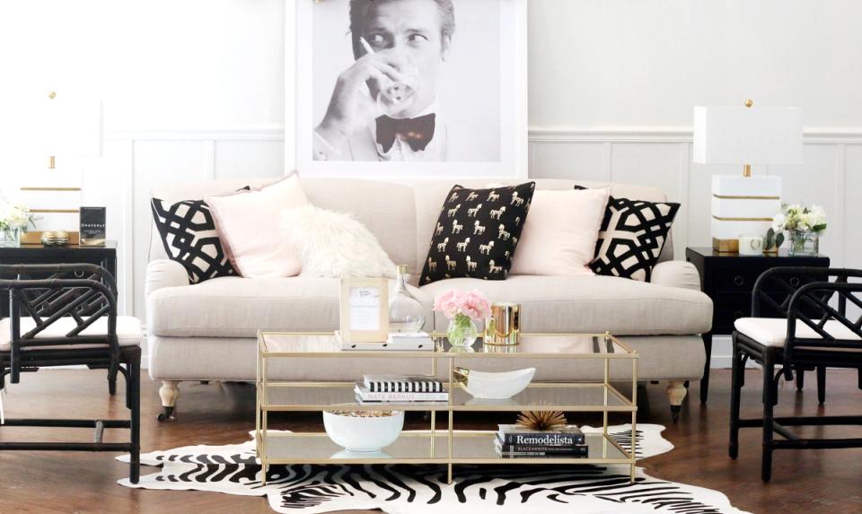 Contemporary living room with cream sofa, black geometric accents, and bold zebra-print rug