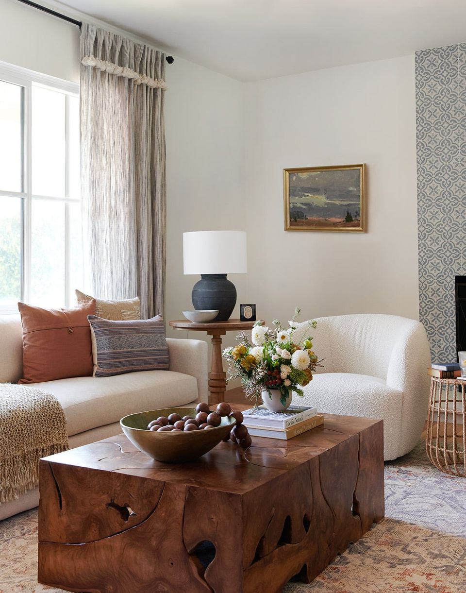 Organic modern living room with warm terracotta accents, natural wood coffee table, cream sofa, and earthy neutral palette creating serene elegance