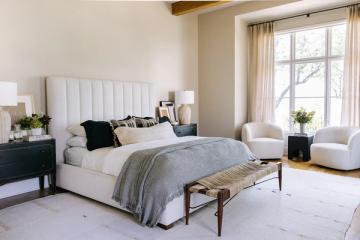 Serene modern bedroom with cream and gray palette, upholstered headboard, soft lighting