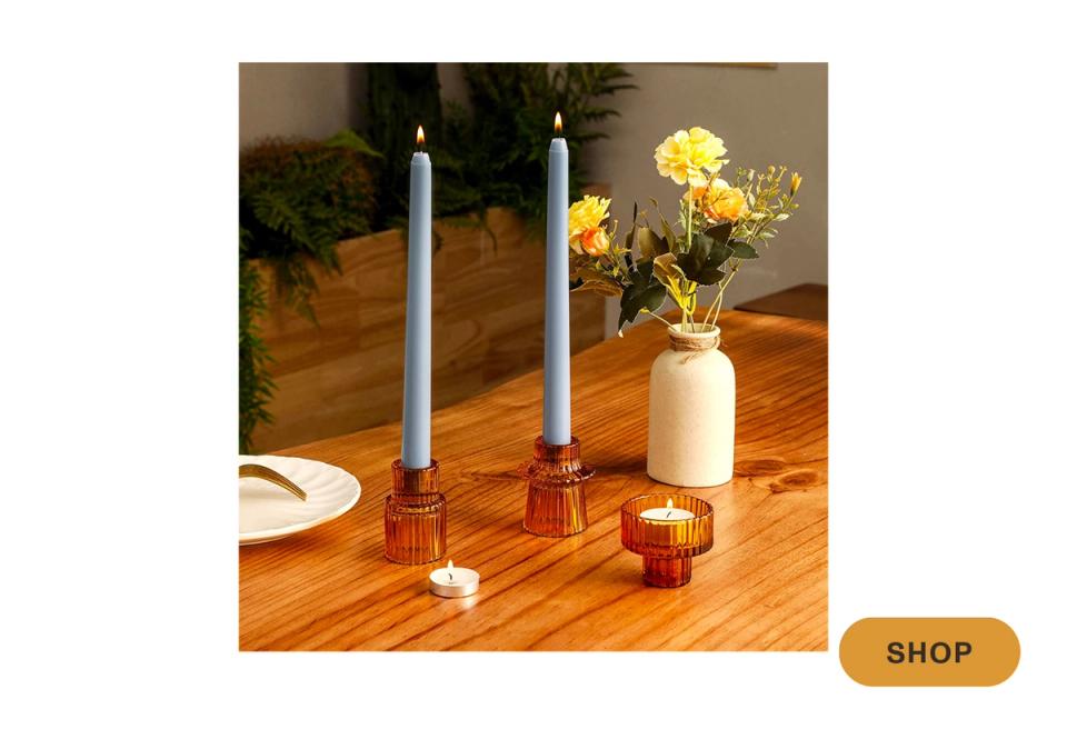 Warm wood table setting with taper candles, ceramic vase, and fresh flowers